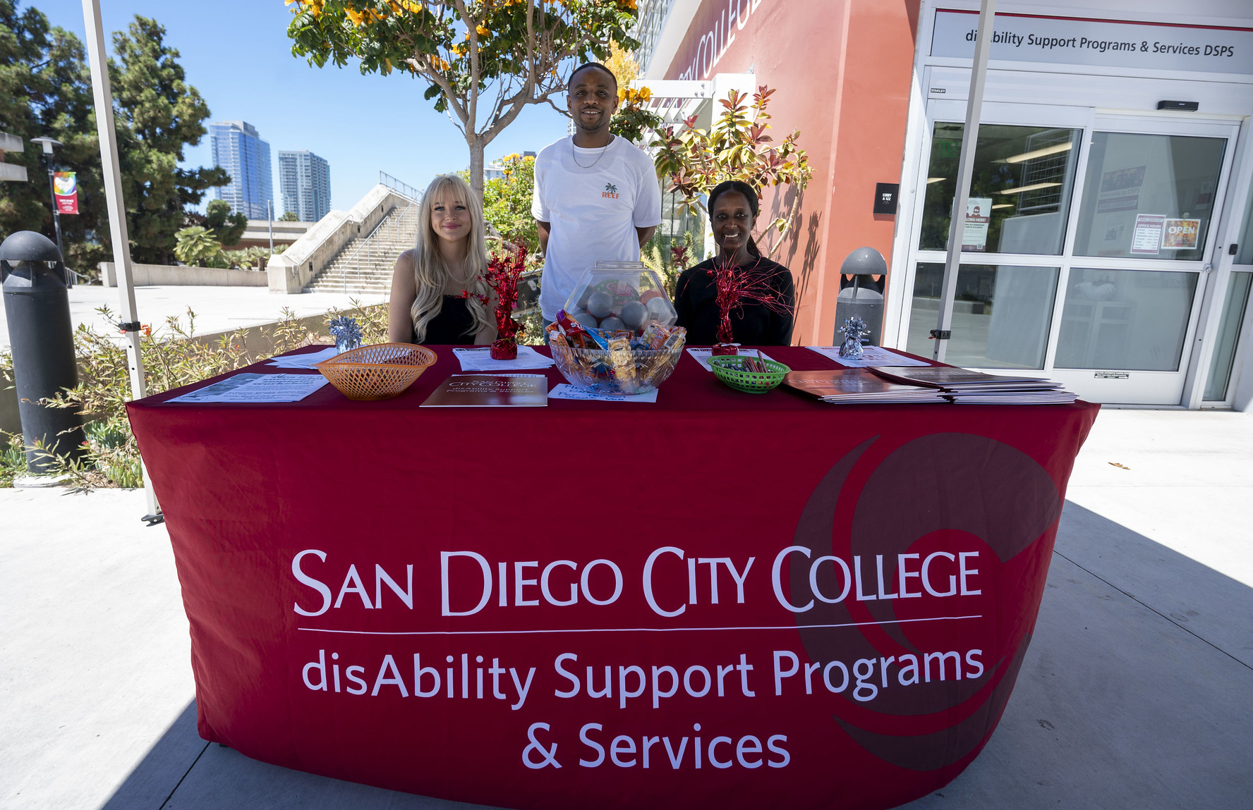 Three people at a table for DSPS at City College Welcome Week