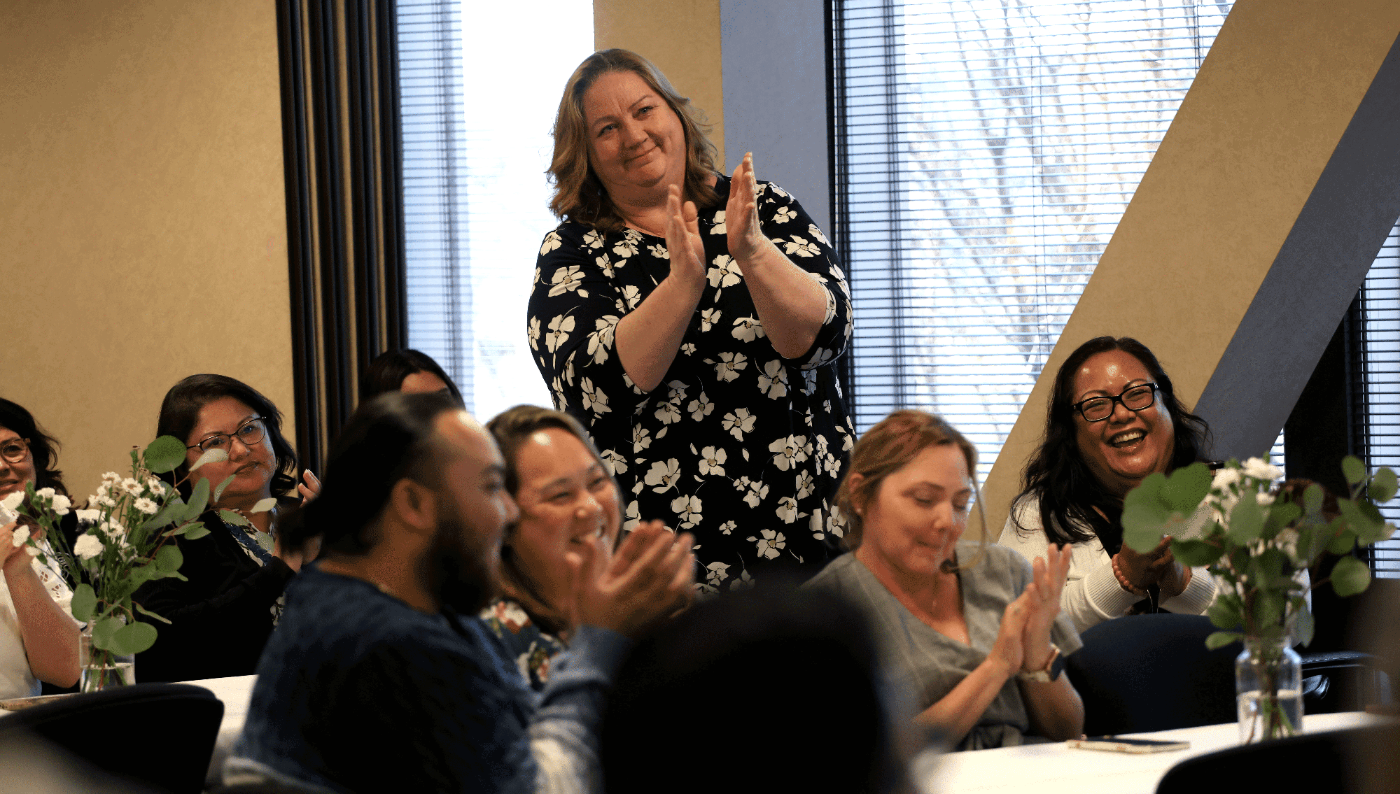 An employee stands and applauds at the chancellor's reception