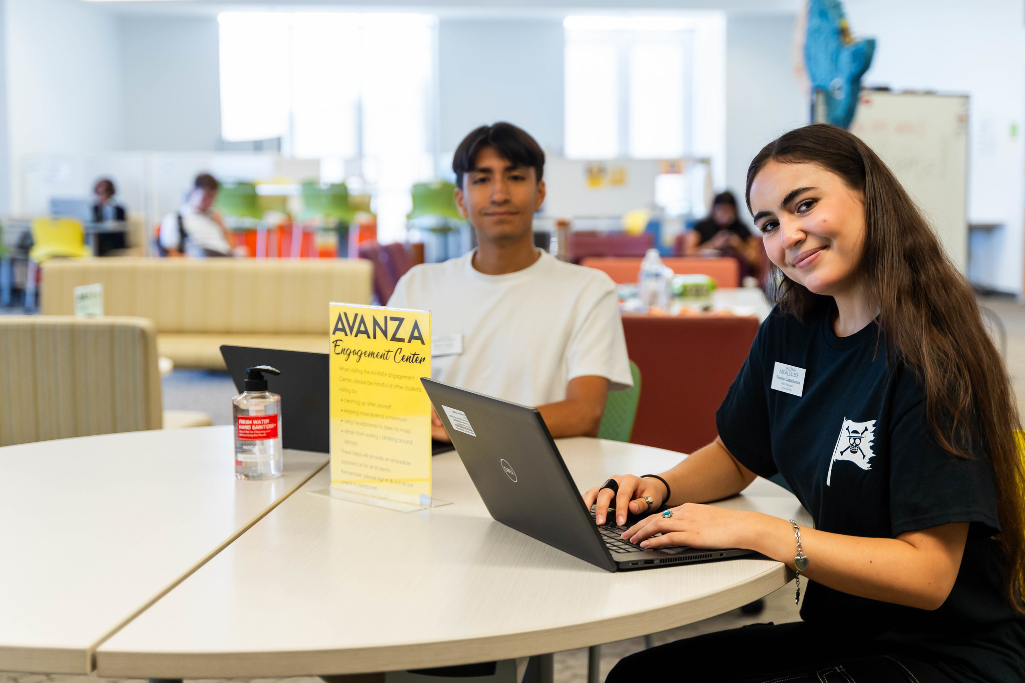 A Mesa student sitting at a table typing on a tablet