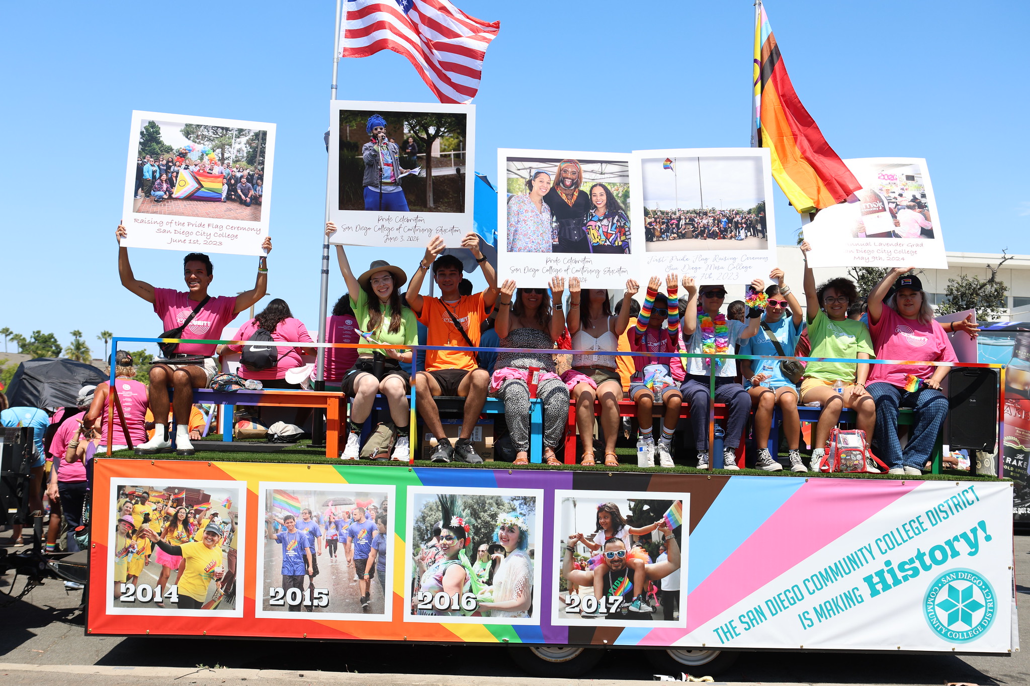 Pride parade float People surround the Pride Parade Float. The float has a pictures all around of students and past pride parades