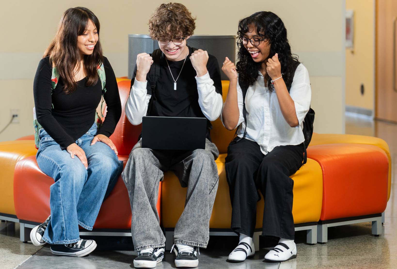 Three students looking at a laptop