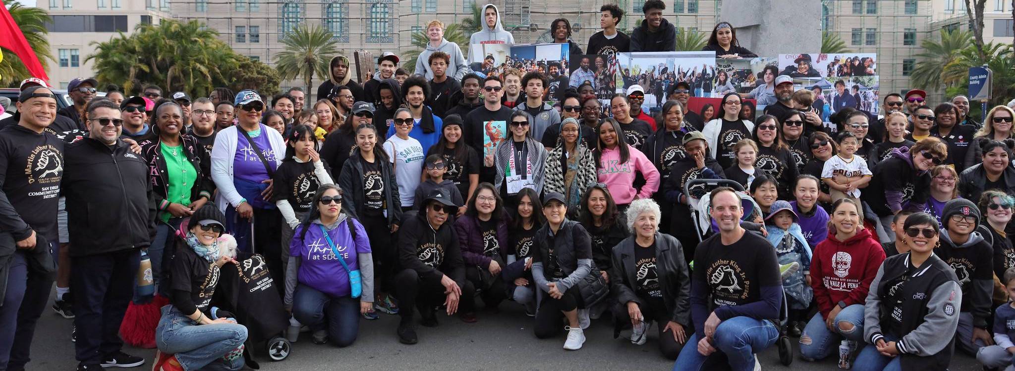 About fifty employees and students take a group photo at the MLK Parade.