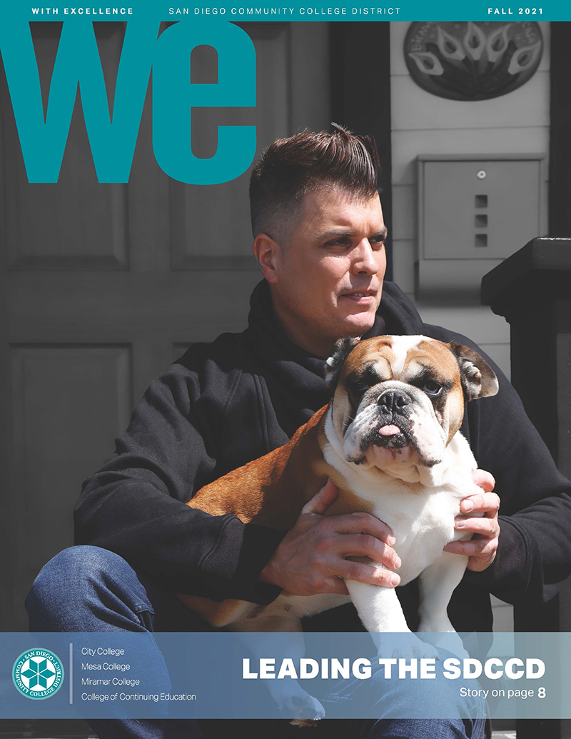 Carlos Cortez sits on outside steps with his brown and white bull dog