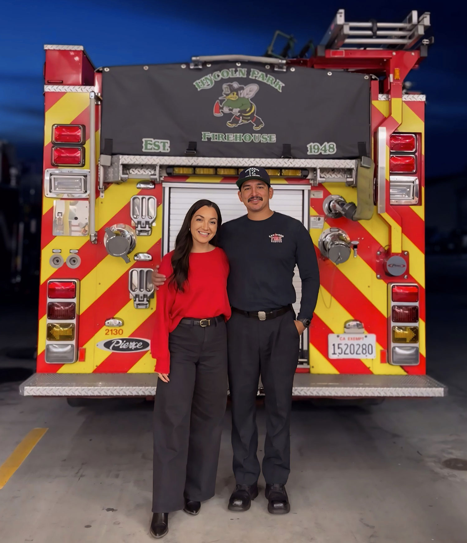 Ulizes Sanchez with his wife standing at the back of a fire truck