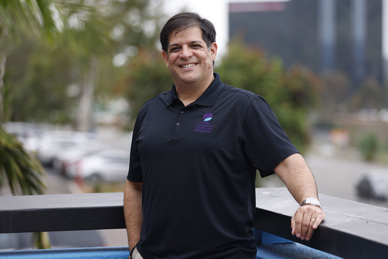 Yahir Melendez wear a black polo shirt and standing on a balcony