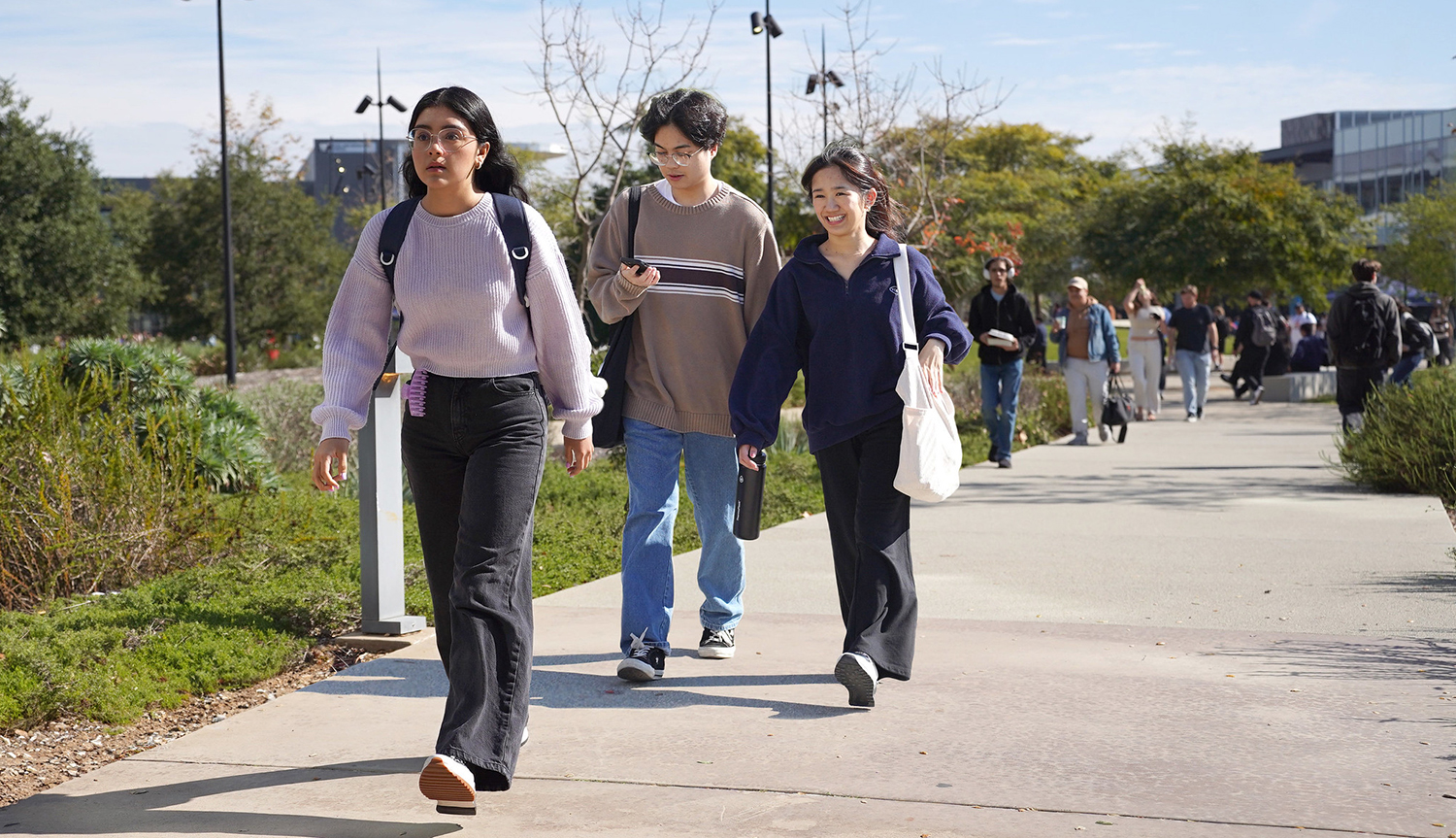 Three students walking on campus