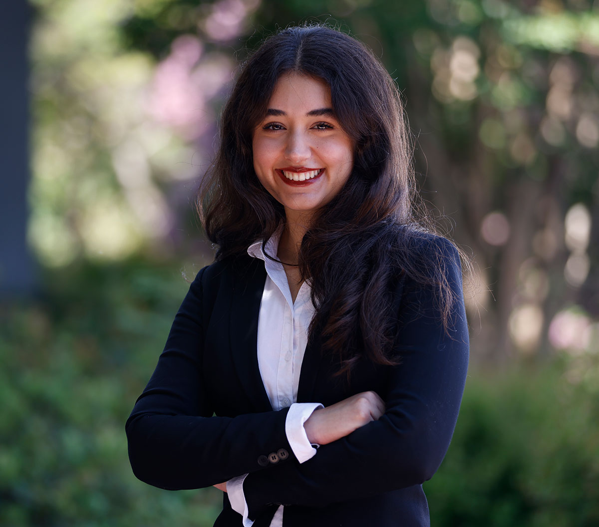 Miranda Augelli in a navy blue blazer outside surrounded by greenery