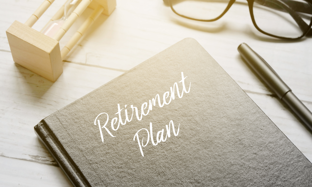 A book that says retirement plan is on a table with a white tablecloth