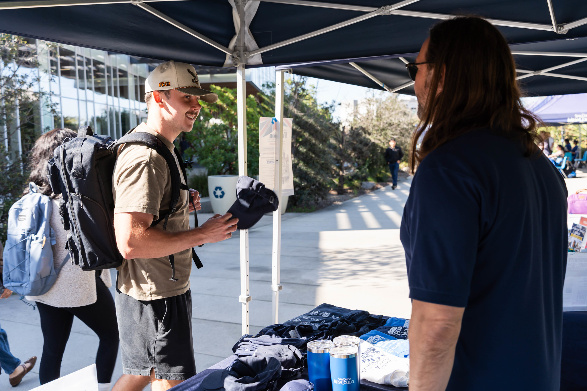 
A student grabs a Mesa College hat at a welcome tent.
